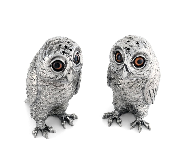 Two silver owl figurines on a white background