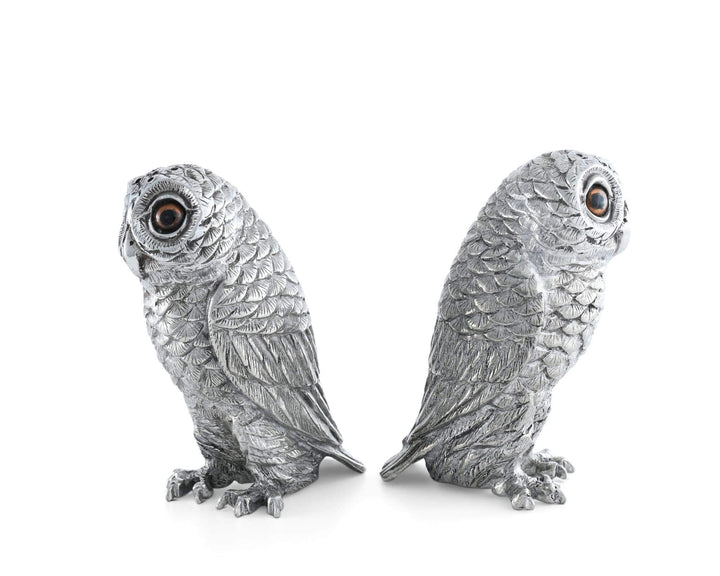 Two silver owl figurines on a white background