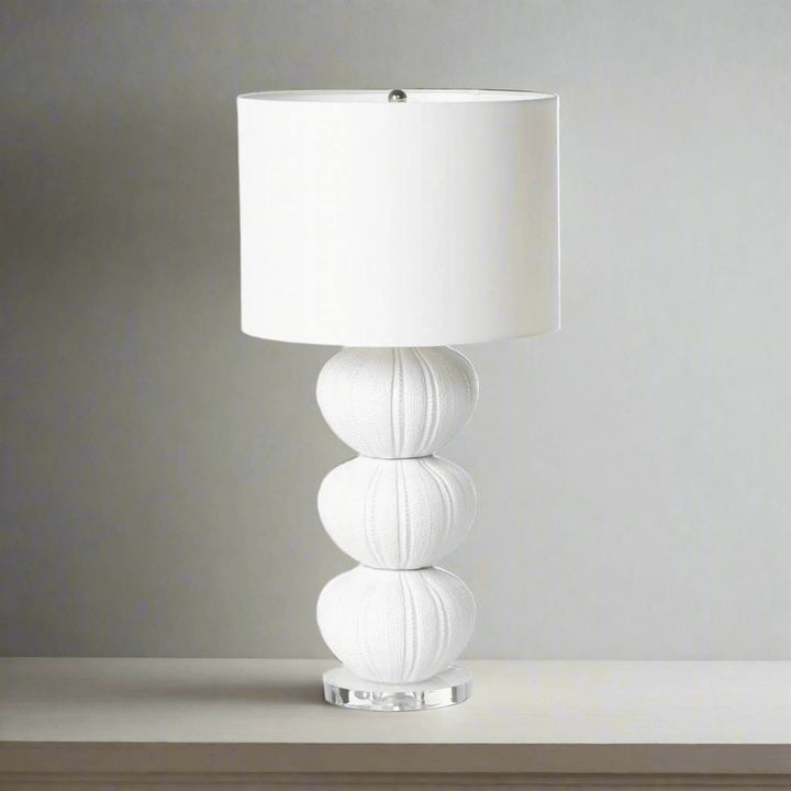 White table lamp with a textured base on a neutral background