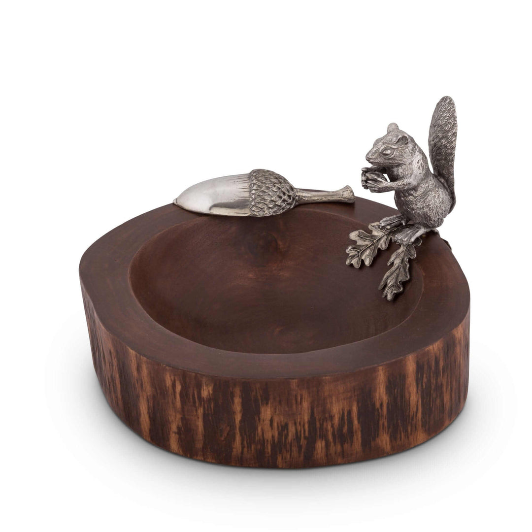 Wooden bowl with a metal squirrel and acorn decoration on a white background