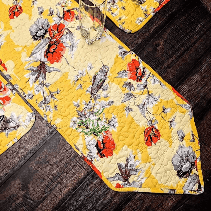 Floral and bird patterned table runner on a wooden surface
