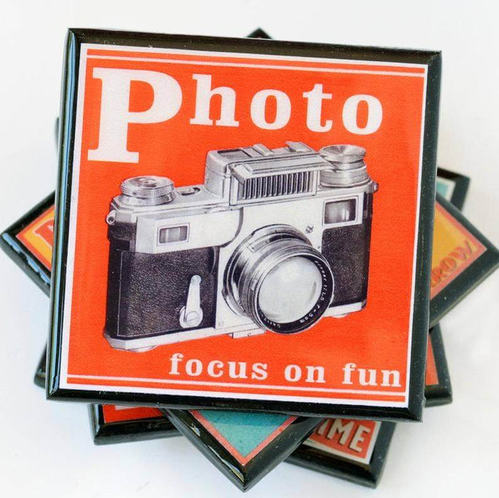 Stack of coasters with a camera design and text on an orange background