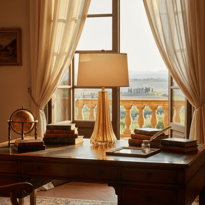 Wooden desk with lamp, books, and globe in a room with large windows and curtains.