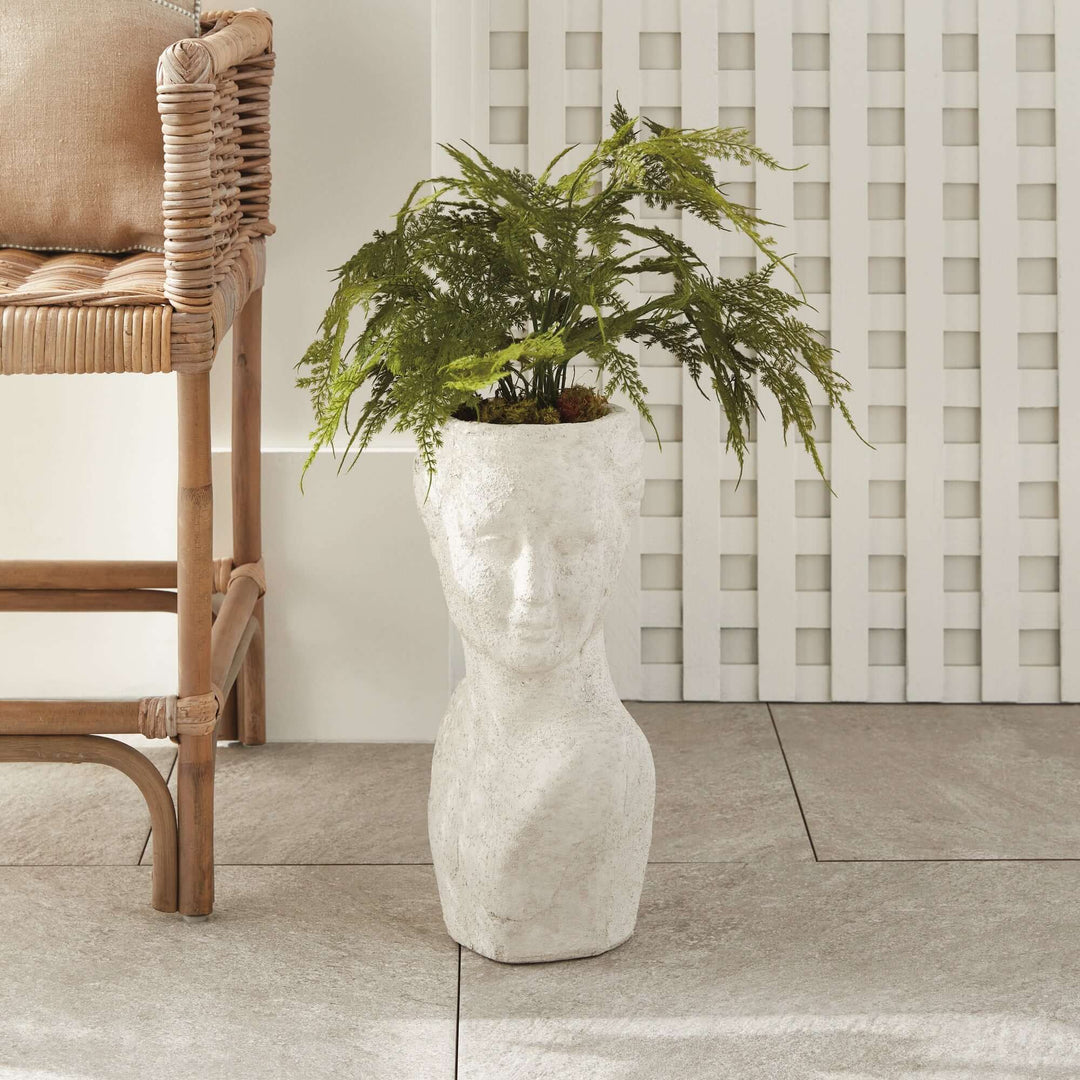 Ancient female bust planter in terracotta, evoking a timeless charm, adorned with lush greenery for outdoor decor.