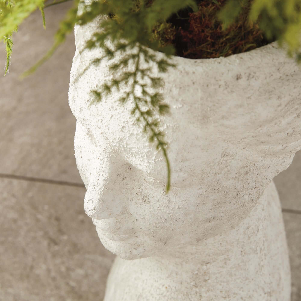 Ancient female bust planter blending art and nature, crafted from terracotta with timeless limestone finish, adorned with greenery.