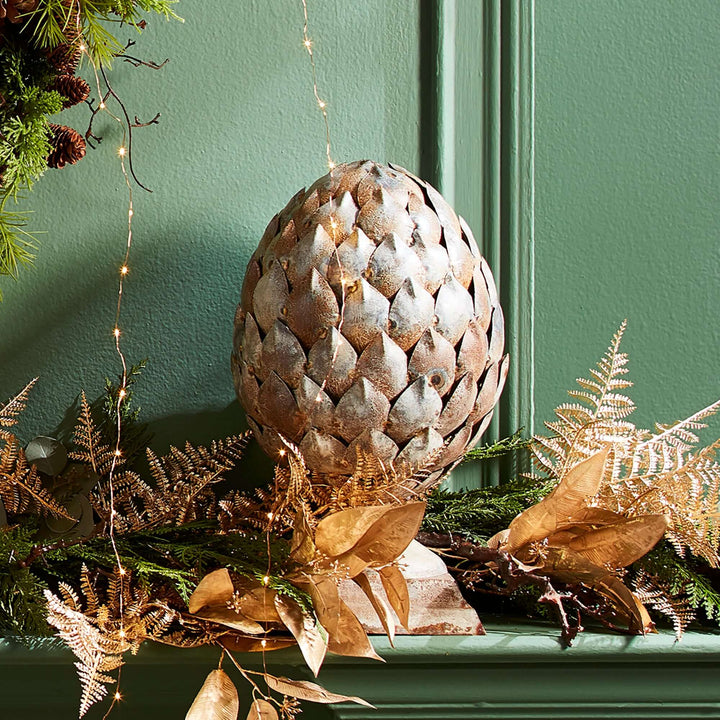 Antique artichoke ornament on pedestal base, showcasing refined Old World character and age-worn materials.