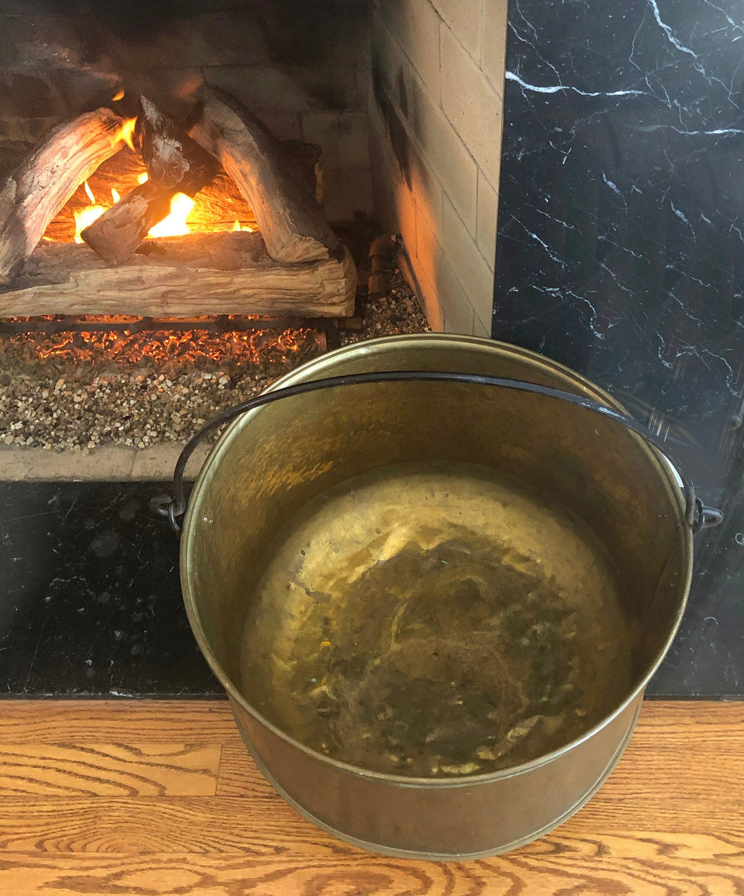 Antique bucket next to a fireplace, showcasing a warm and inviting ambiance.