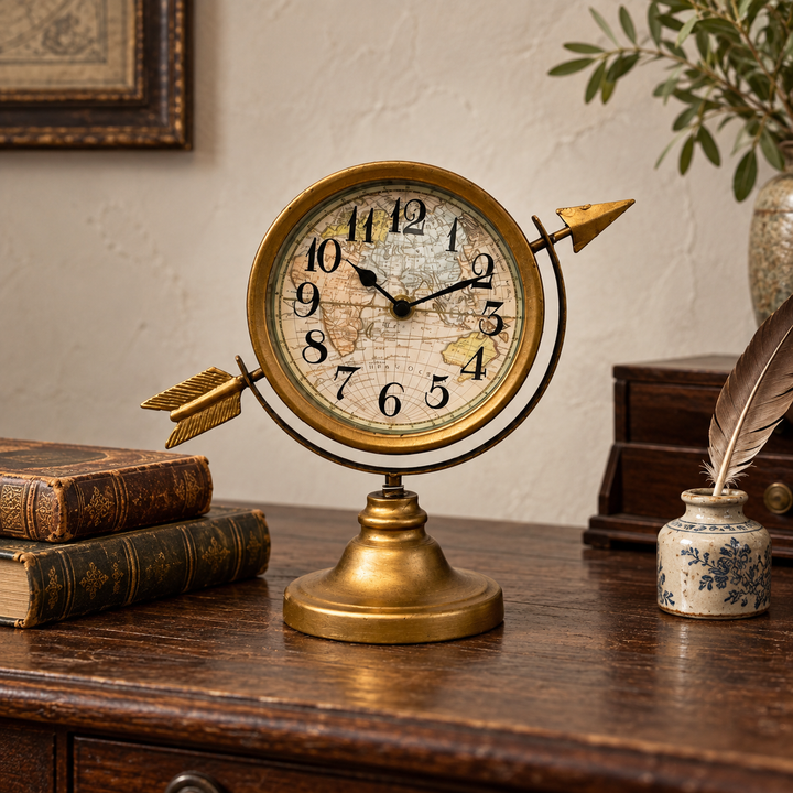 Antique gold arrow table clock styled on a dark wood writing desk