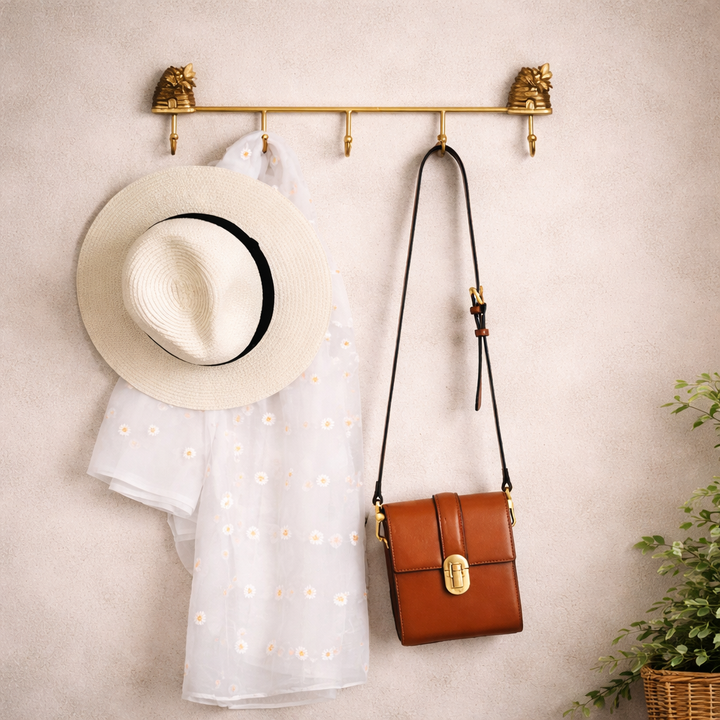 Antique gold beehive wall hook rack styled with a hat and shoulder bag