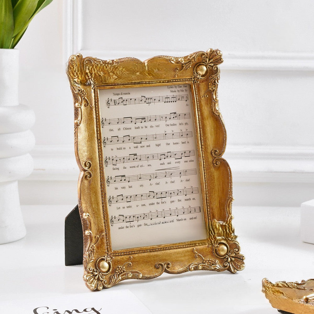 Medium Antique Gold Scrollwork Picture Frame on a white tabletop