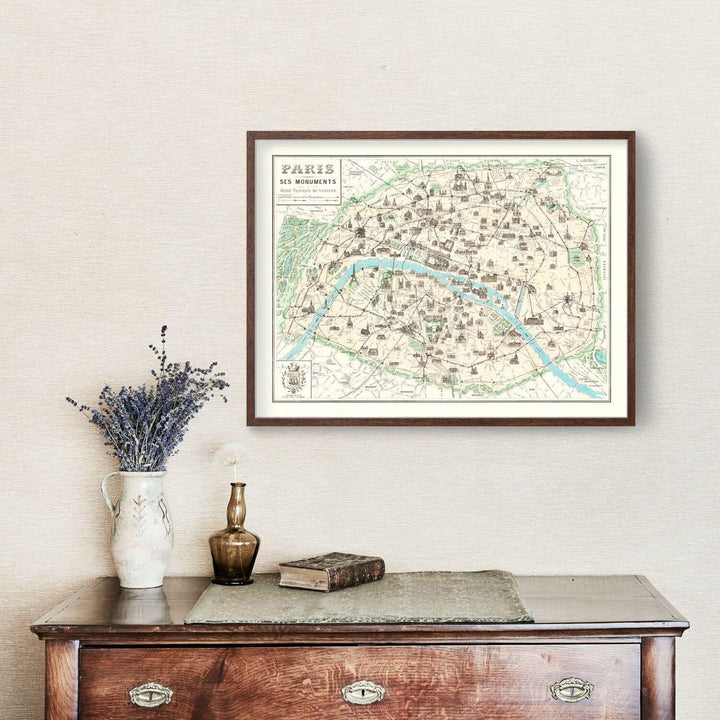 Antique Map of Paris, France from 1905 displayed in a frame above a wooden dresser with decorative items.