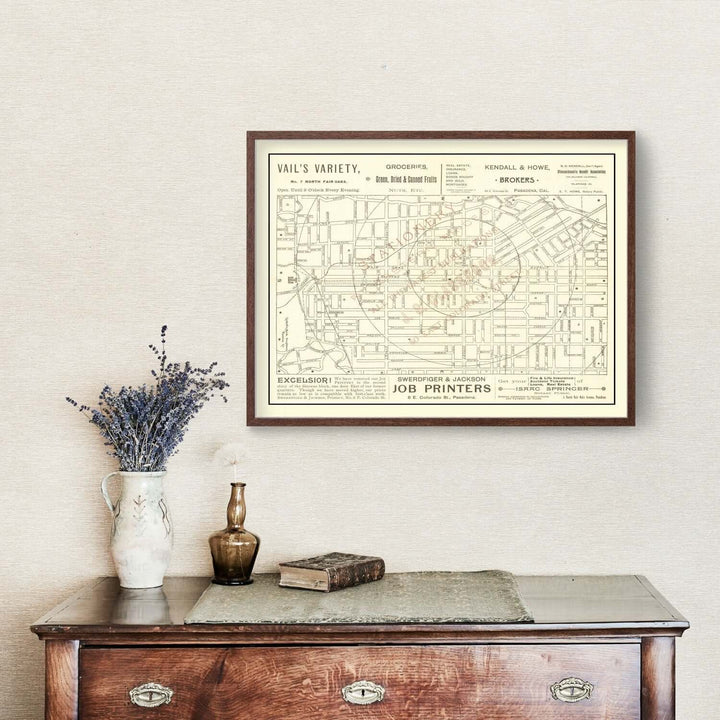 Antique Map of Pasadena, California from 1893 framed on a wall above a vintage dresser with flowers.