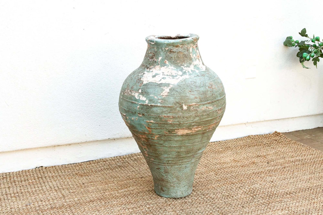 Antique Mediterranean Terracotta Pottery Vessel on woven mat, exemplifying coastal elegance and handcrafted artistry.