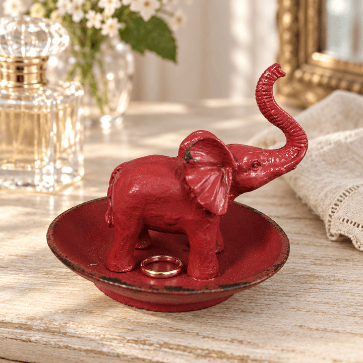 Antique Red Pewter Elephant Ring Dish holding a ring on a dressing table