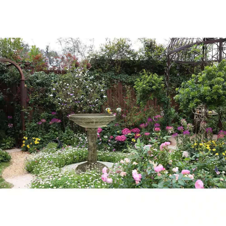 Antique-Style Garden Bird Bath in Aged Granite among lush garden flowers