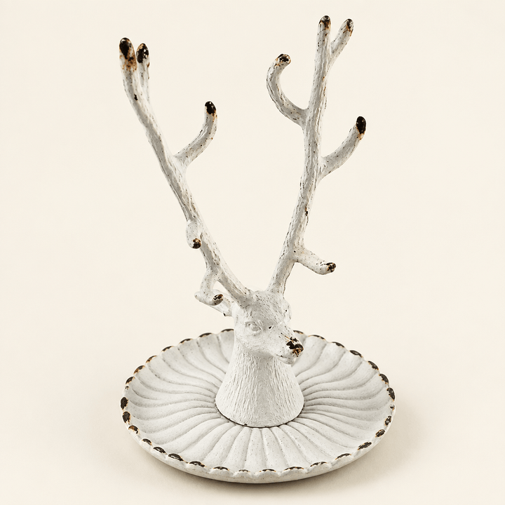Antique white pewter stag jewelry dish with branching antlers on an ivory studio background