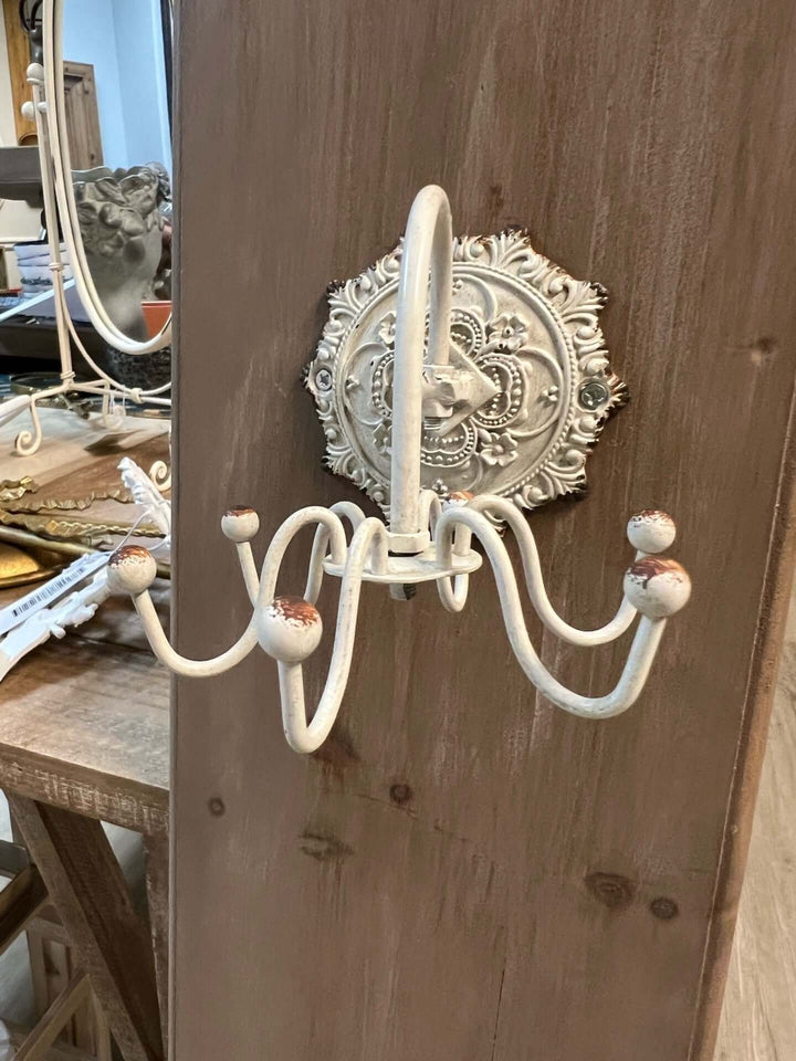 Antique white wall hook with ornate medallion backplate, adding vintage European charm to any decor.