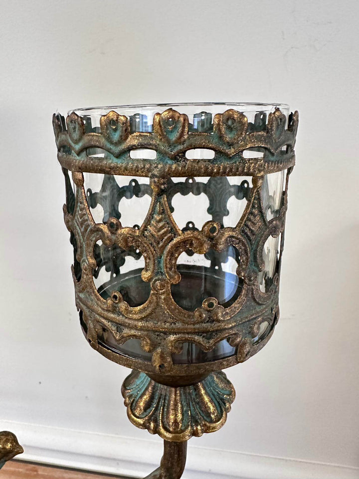 Antique amber glass votive candle holder centerpiece with intricate metal latticework design.