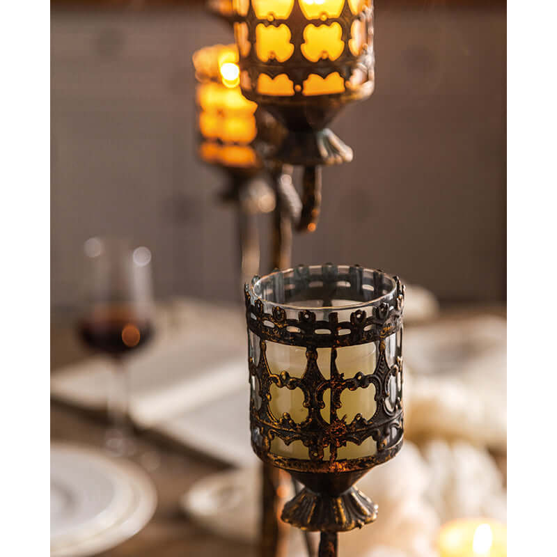 Antique amber glass votive candle holder centerpiece with intricate metal latticework, perfect for elegant dining settings.