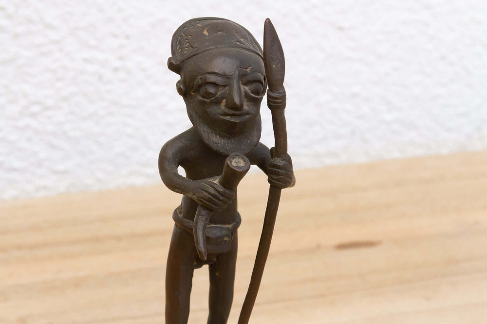 Antique Bamum Bronze Warrior Figure from Cameroon sculpture on wooden surface