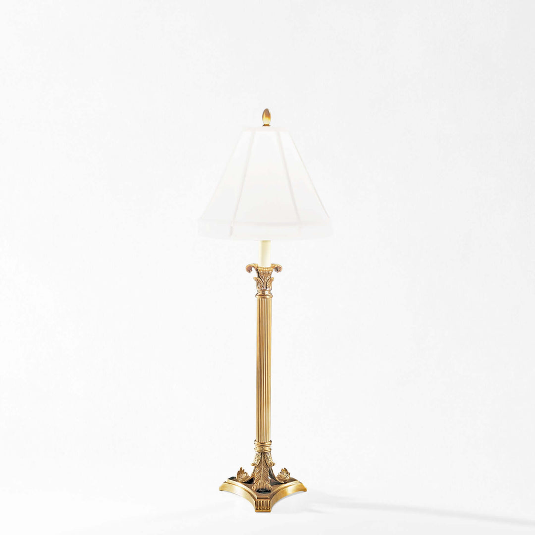 Decorative gold lamp with white shade on a white background