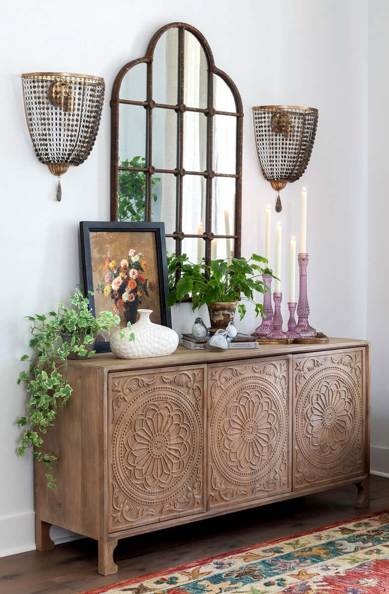Elegant living room featuring antique gold crystal wall sconces, vintage chain shades, ornate cabinet, and decorative accents.