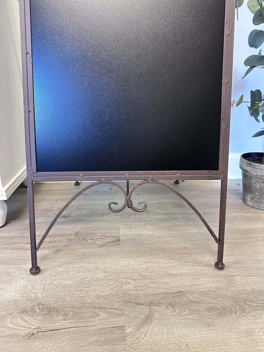 Antique iron chalkboard easel with intricate scrollwork and bird accents, perfect for vintage décor and nostalgic messages.