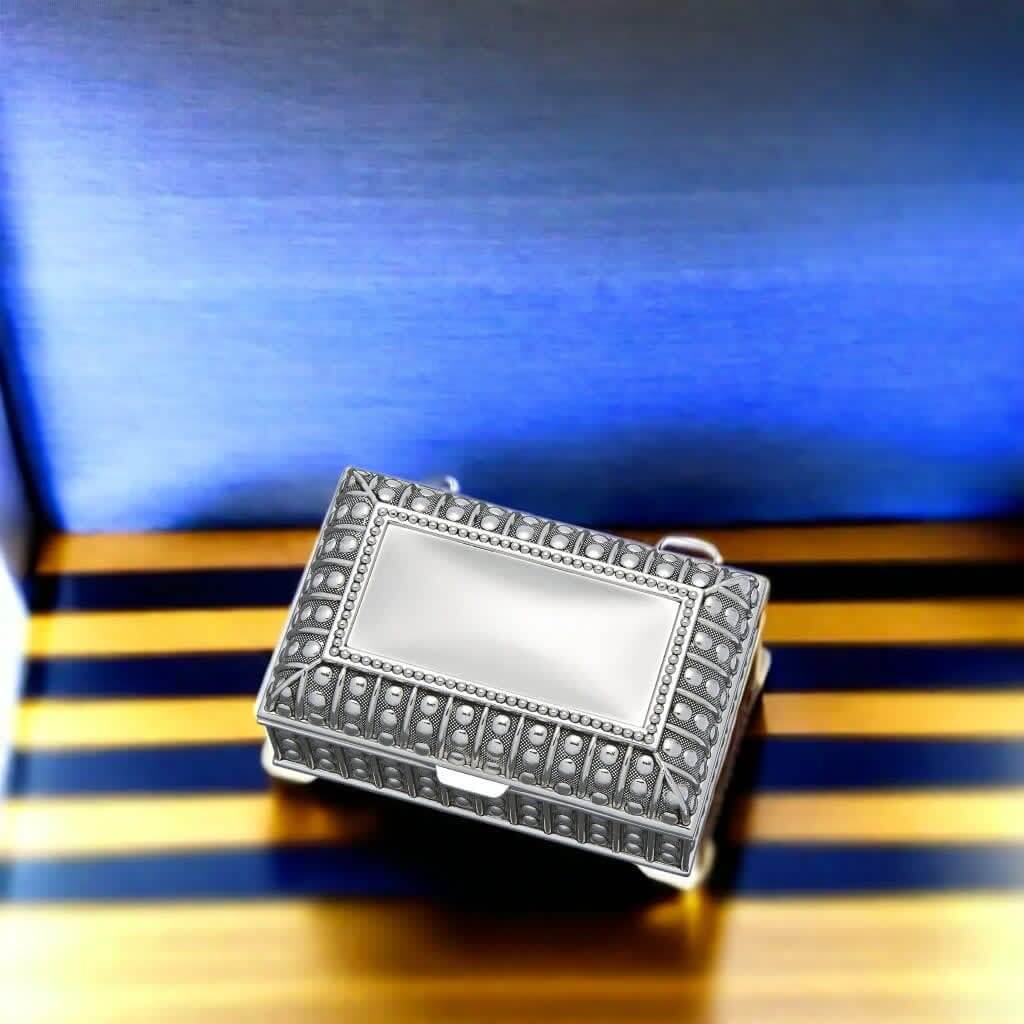 Antique-Style Silver Jewelry Box with ornate beaded detailing and vintage charm on a wooden striped surface.