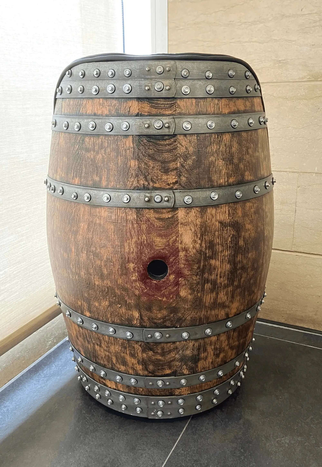 Rustic wooden barrel with metal rivets in natural light