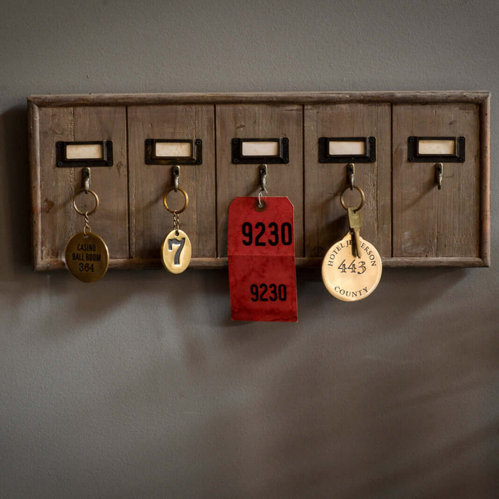Antique wooden hotel key rack organizer with vintage keys on weathered wood, evoking a sense of historical hospitality charm.