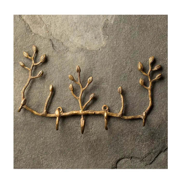 Antiqued brass branch key holder mounted on a textured slate wall