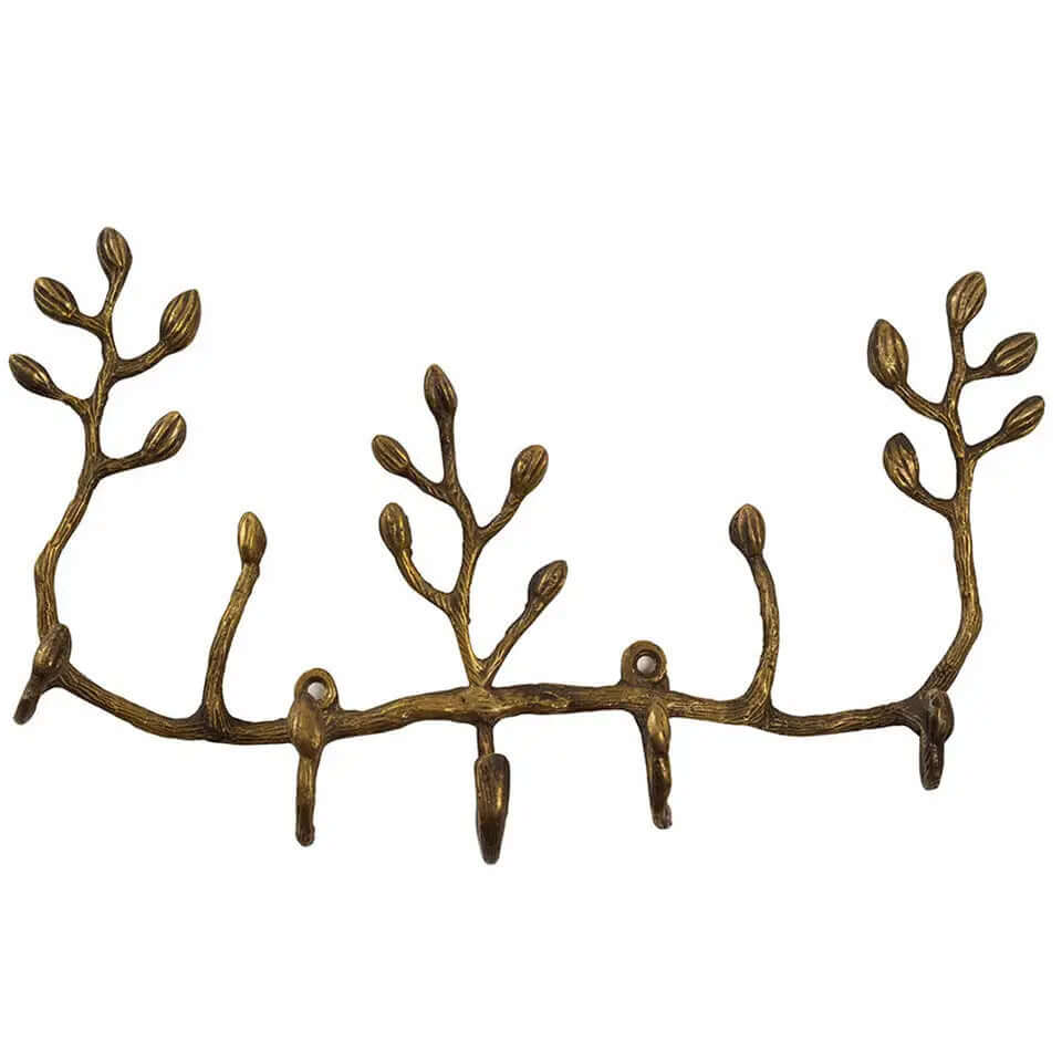 Twig-shaped antiqued brass wall key holder with leaf buds and five hooks on white