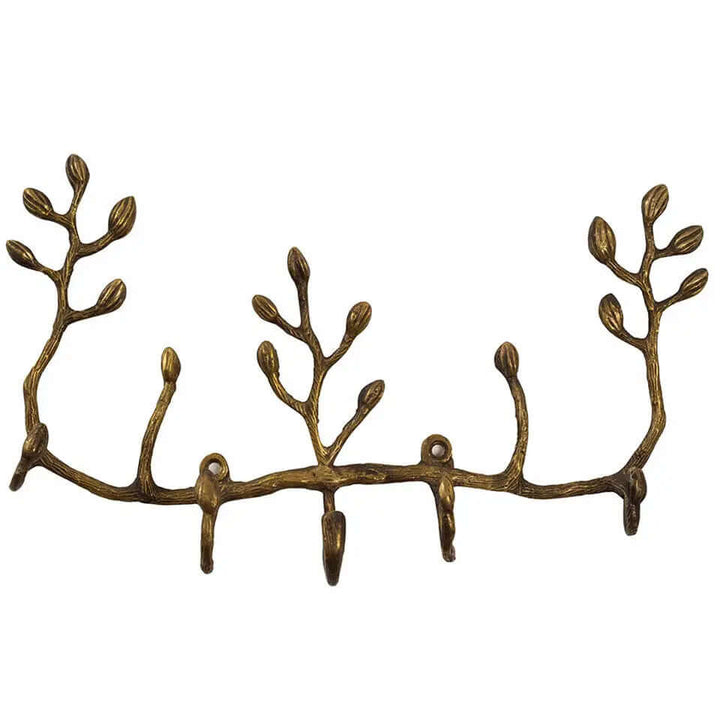 Twig-shaped antiqued brass wall key holder with leaf buds and five hooks on white