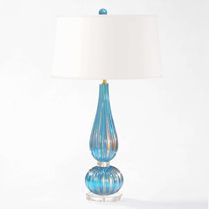 Blue glass table lamp with white shade on a white background