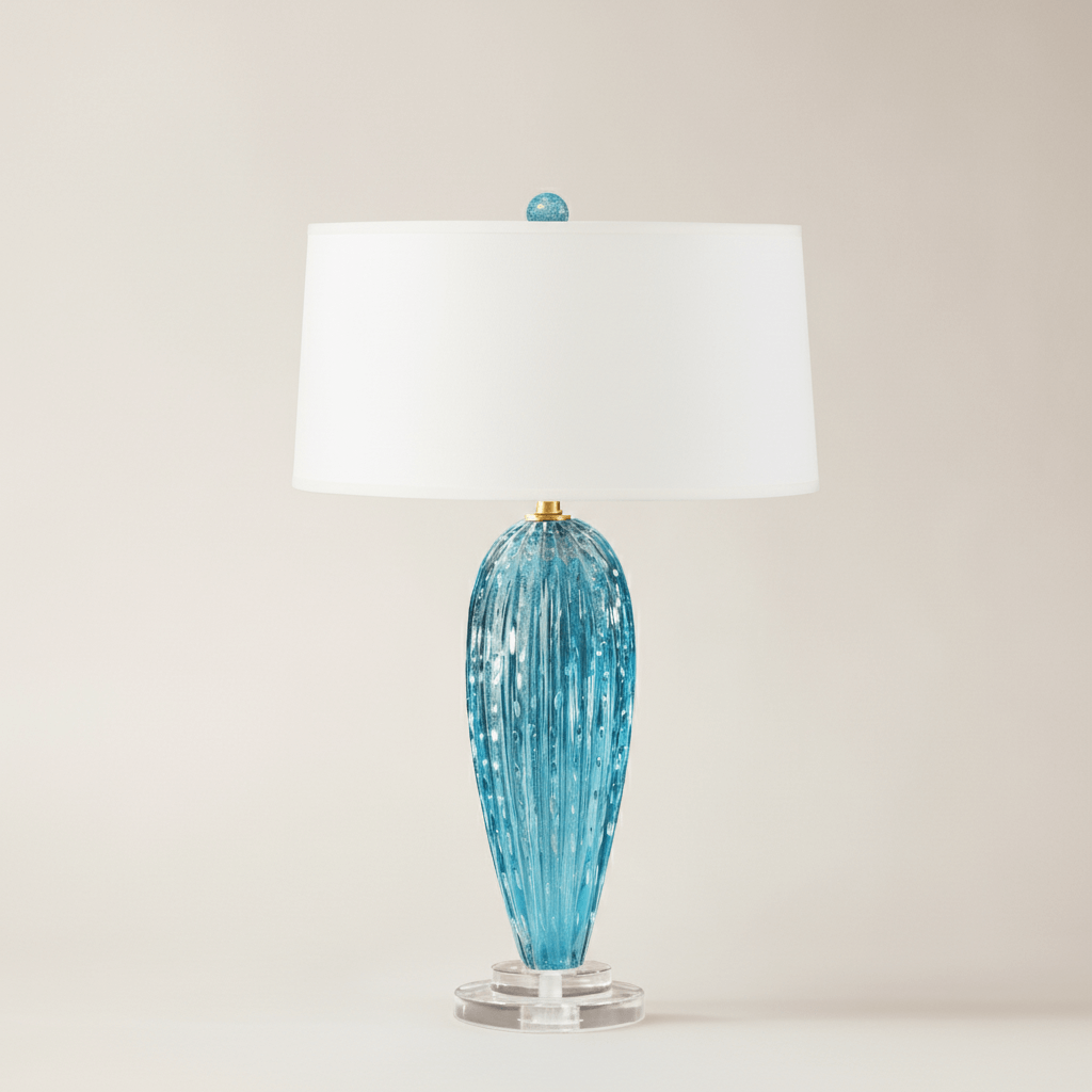 Blue glass table lamp with a white shade on a beige background