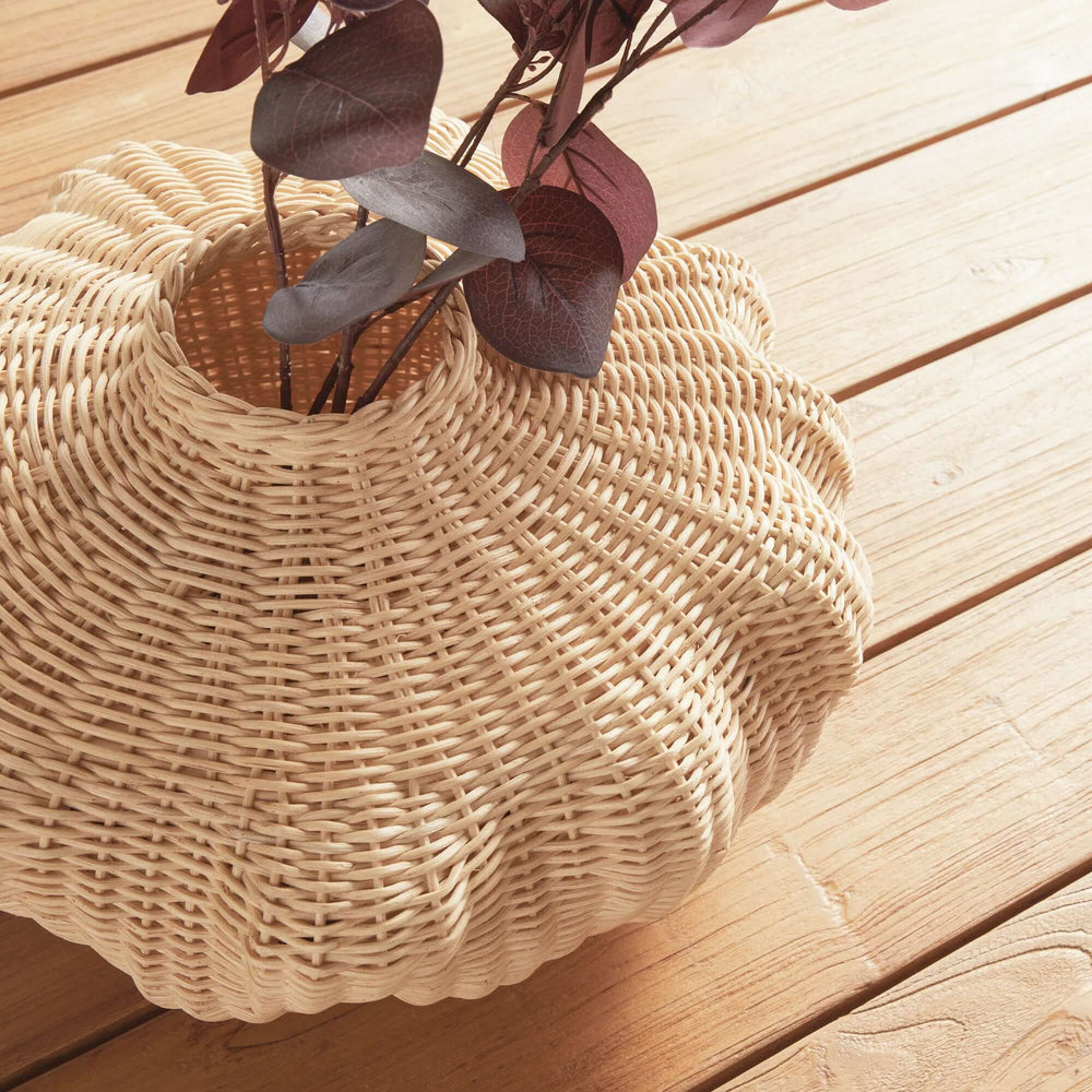 Handcrafted rattan vase with coastal design on wooden floor, featuring natural texture and driftwood-like curves for boho décor.