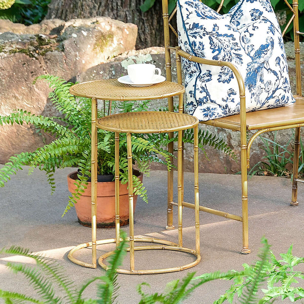 Bamboo Style Iron Nesting Tables Set with natural glaze finish next to a decorative chair and potted plants on a patio.