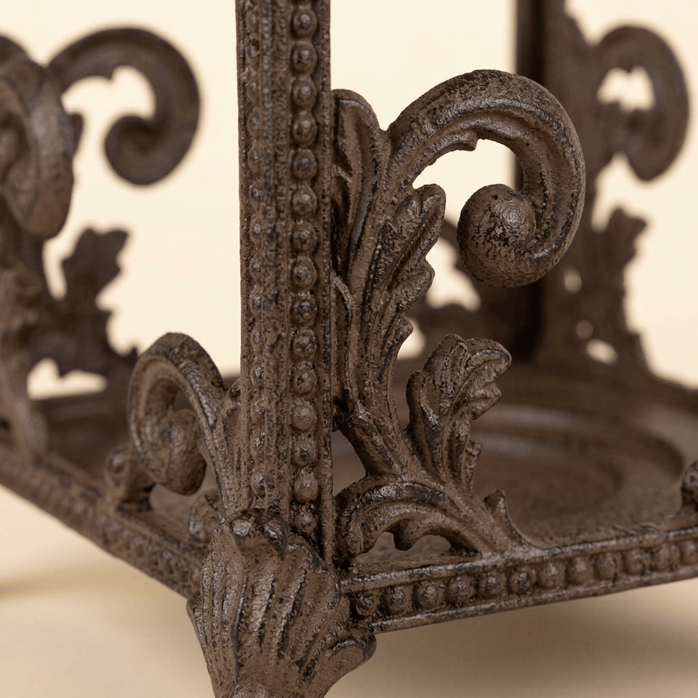 Close-up of Bellavita Acanthus Lantern brown leaf scrollwork, beaded frame and curled foot
