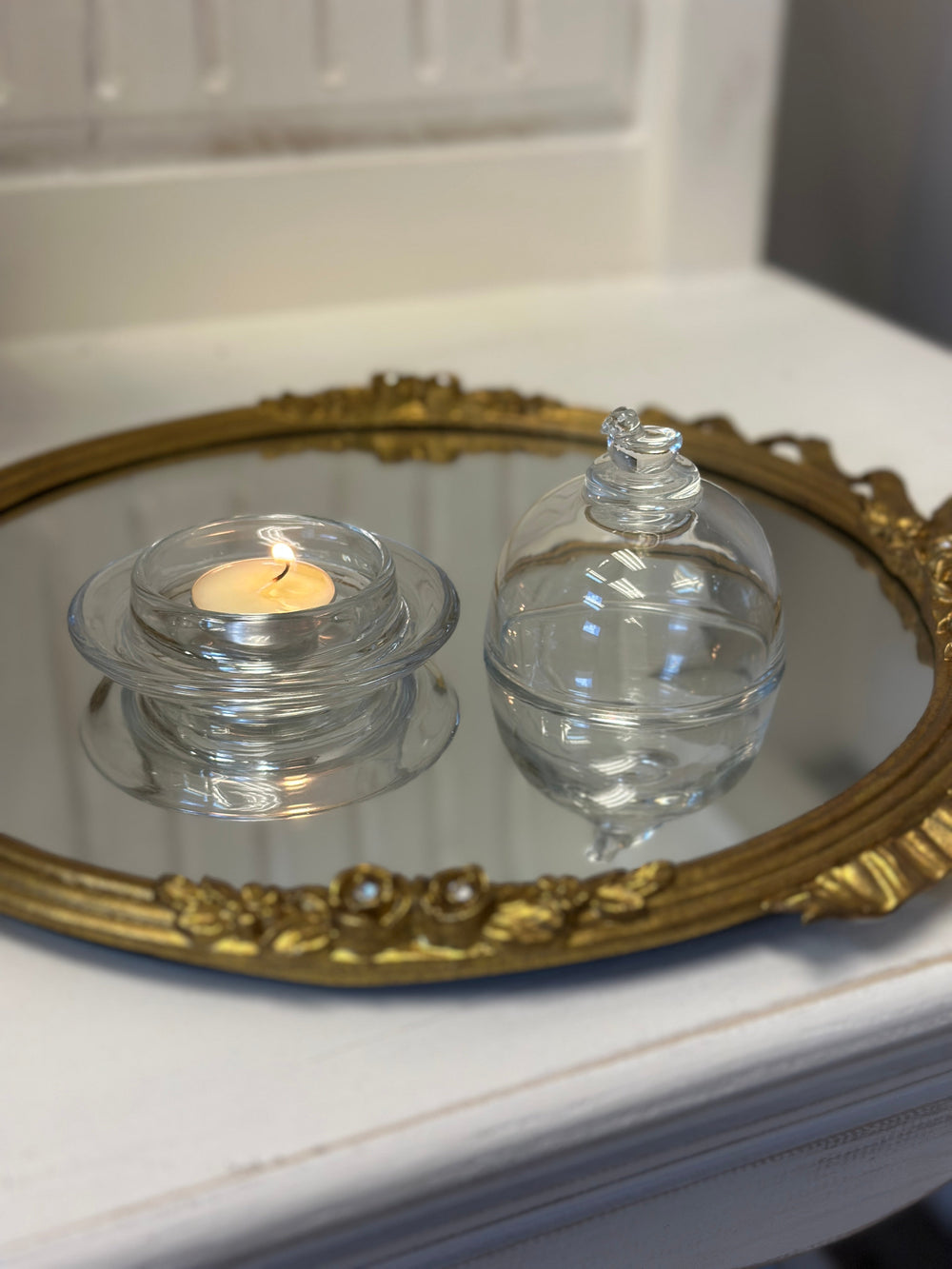 Bird-Topped Glass Cloche covering a glowing tea light on an ornate tray