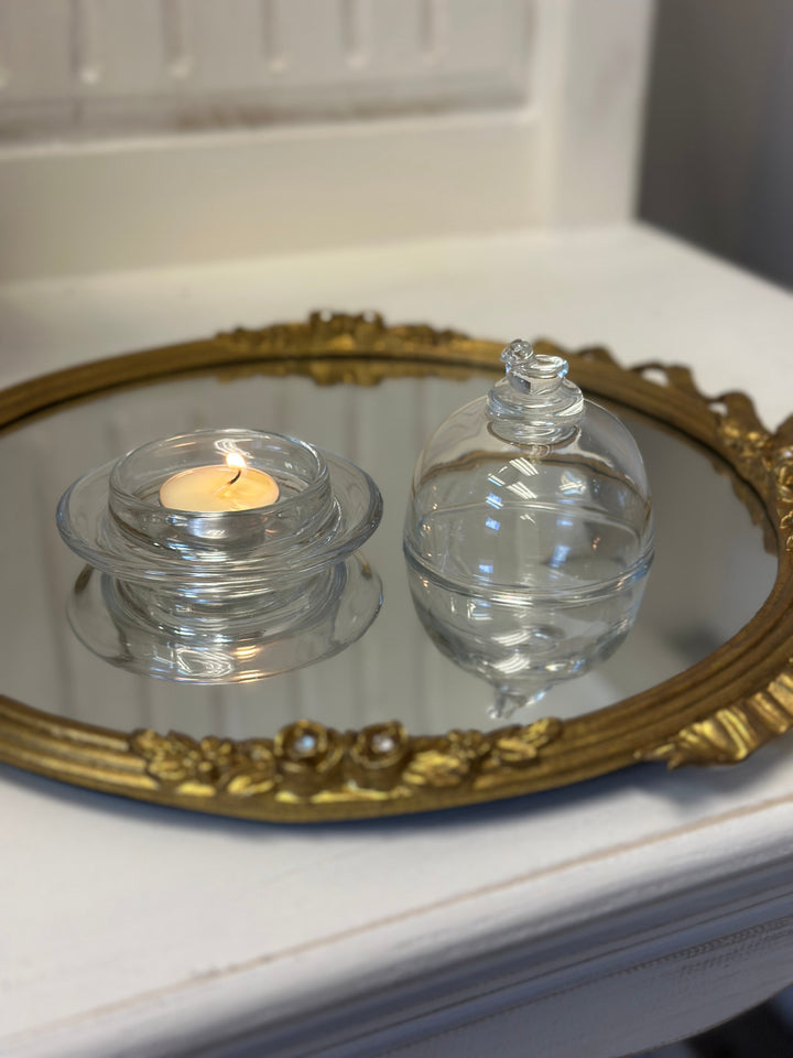 Bird-Topped Glass Cloche covering a glowing tea light on an ornate tray