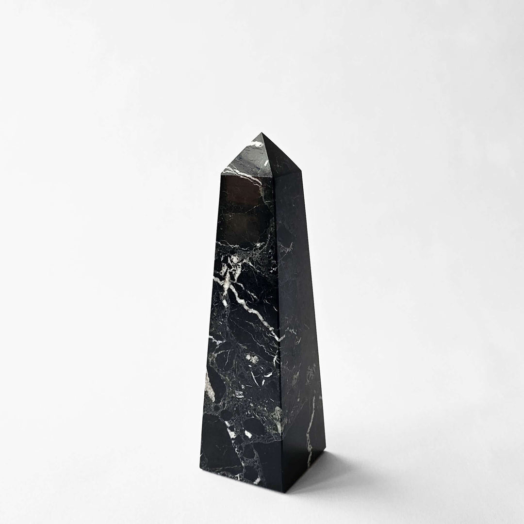 Black marble obelisk on a white background