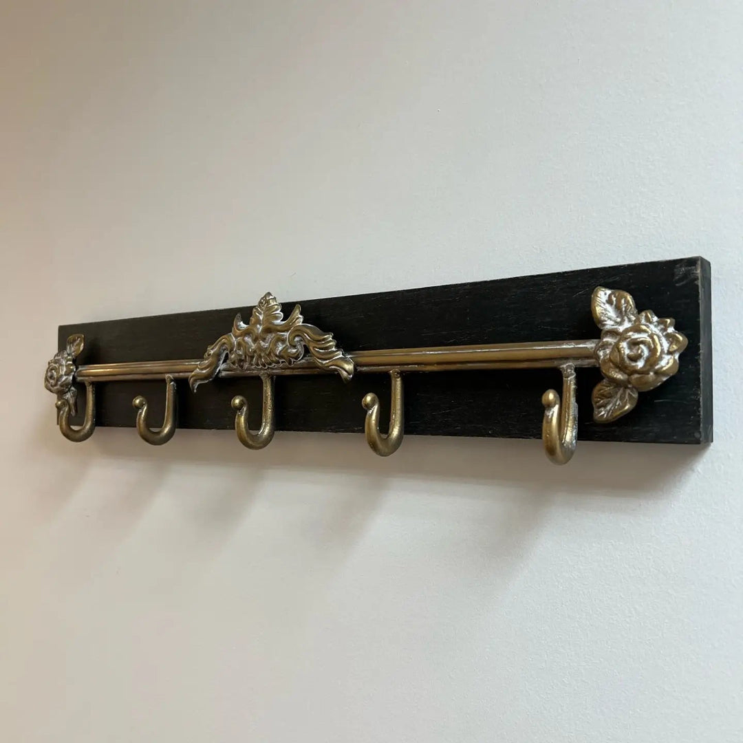 Angled view of the empty black wood wall rack and five hooks