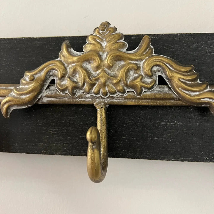 Close view of the wall rack central scroll ornament and hook