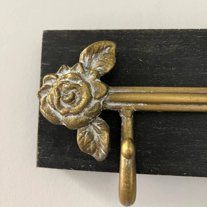 Close view of a gold rose ornament at the end of the wall rack