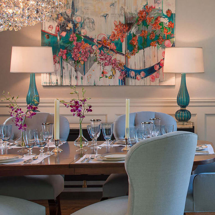 Dining room with a table set for dinner, chairs, table lamps, and decorative elements.