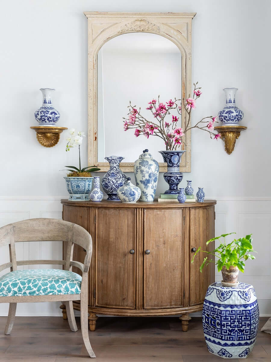 Elegant room with blue and white Chinoiserie porcelain vases, a wooden cabinet, and a decorative garden stool.