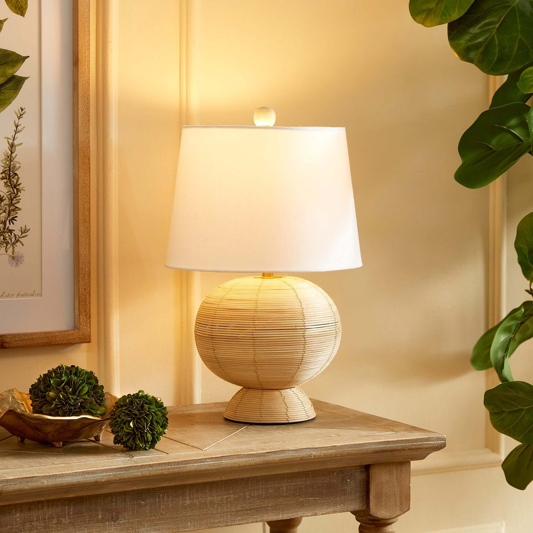 Boho globe rattan lamp with tapered white shade, adding warmth and style to a cozy interior.