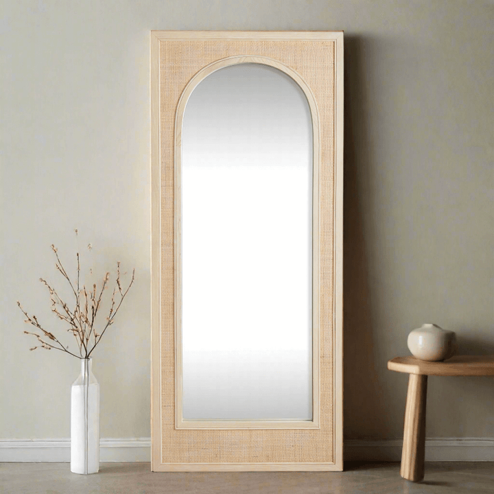 Boho rattan wall mirror in tall arched design, showcasing earthy texture and elegant craftsmanship in a stylish space.