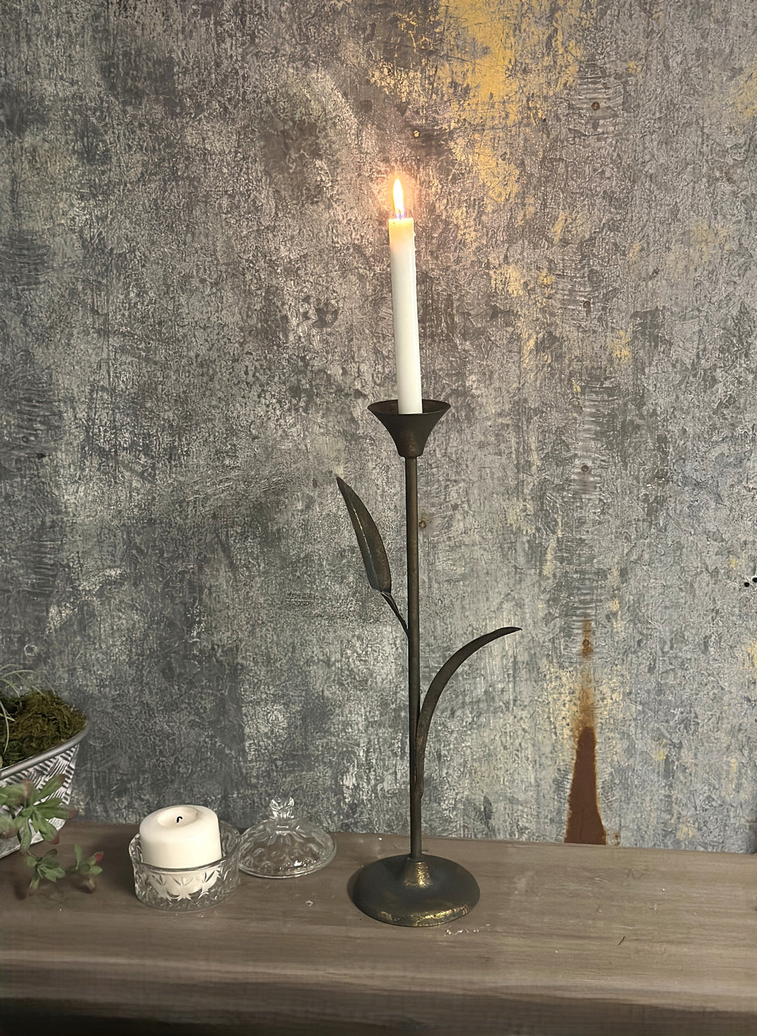 Small Botanical Iron Taper Candle Holder against a textured wall