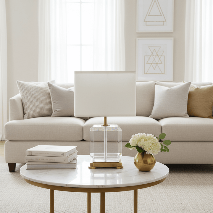 Living room with a beige sofa, round marble table, and decorative items.